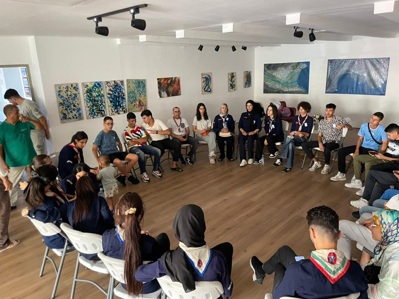 Young people and scout leaders gathered in a circle during an international exchange event.